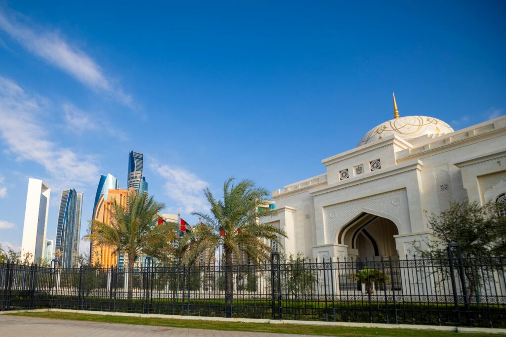 A breathtaking view of Abu Dhabi's skyline with a stunning mosque in the foreground under a clear blue sky.