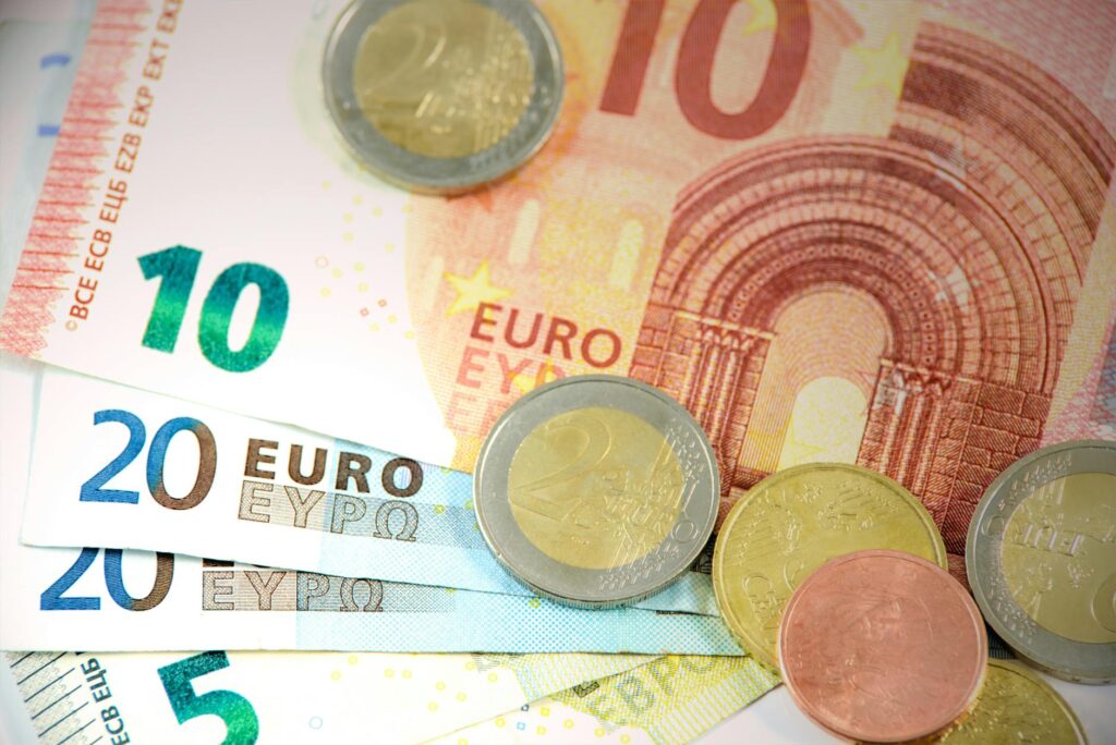 Detailed shot of Euro banknotes and coins showcasing currency denominations.