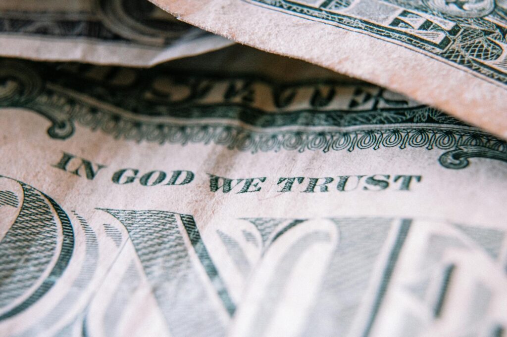 Detailed close-up of a US dollar bill showing 'In God We Trust' motto.