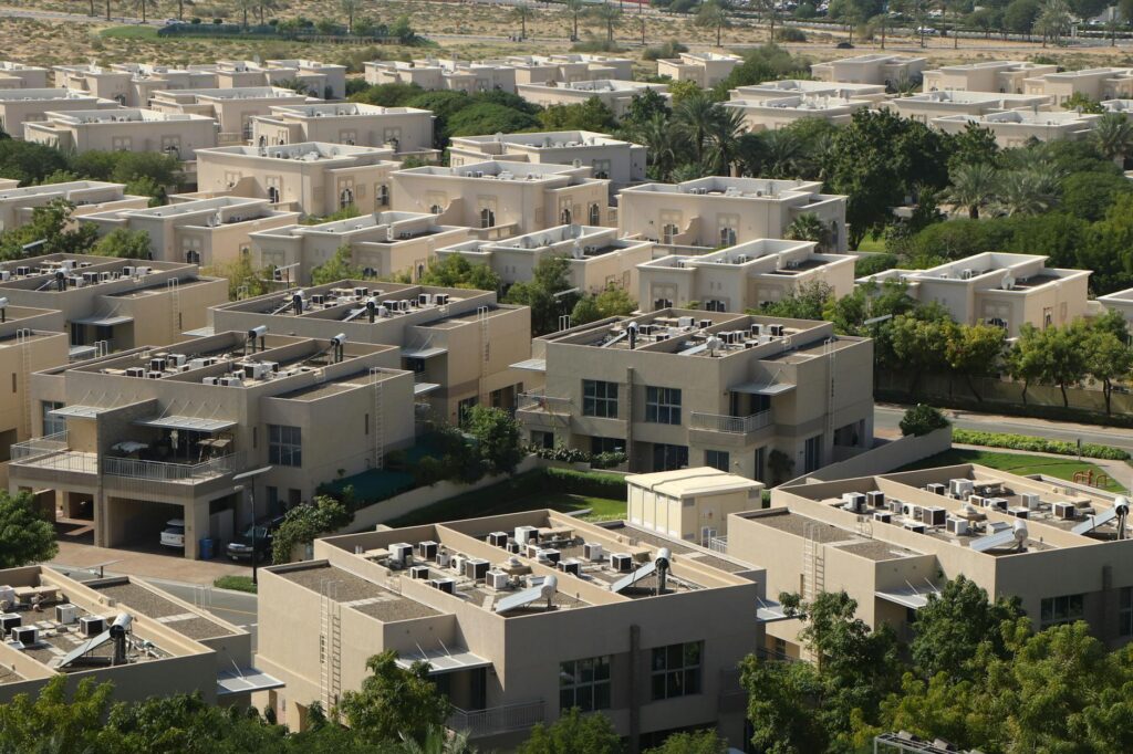 Aerial view of modern residential villas surrounded by greenery in Dubai.